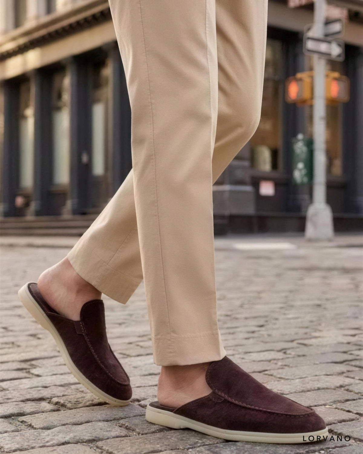 Dark brown suede slippers worn mid-stride