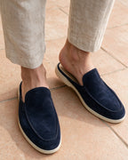 Navy suede slippers worn, open heel visible from above