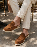 Cognac suede slippers worn seated outside a cafe