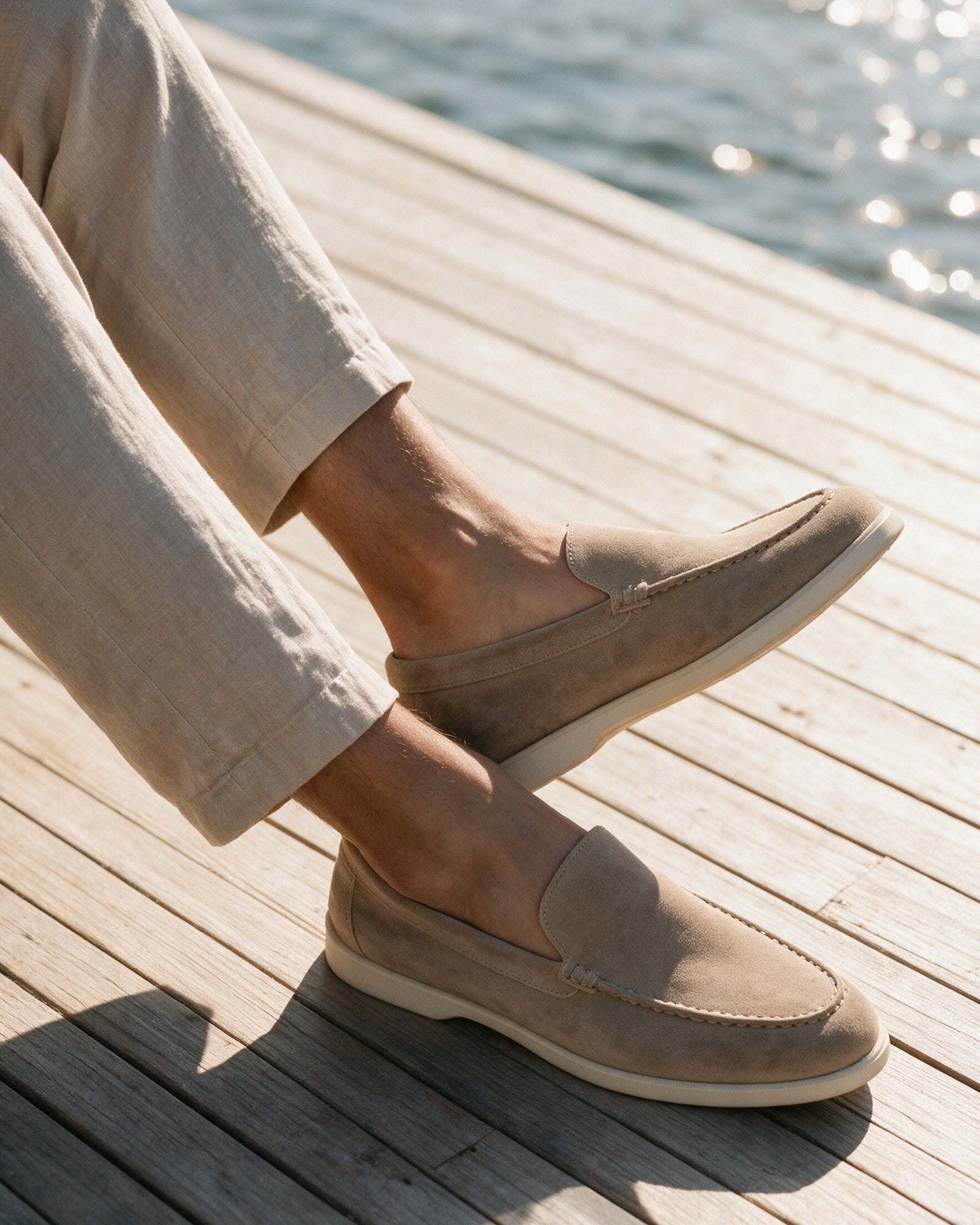 Lorvano Beige Yacht Loafers in sand suede worn on sun-bleached decking by the water